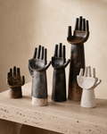Raised hand sculpture set in dark bronze on dark wooden sideboard - dramatic display